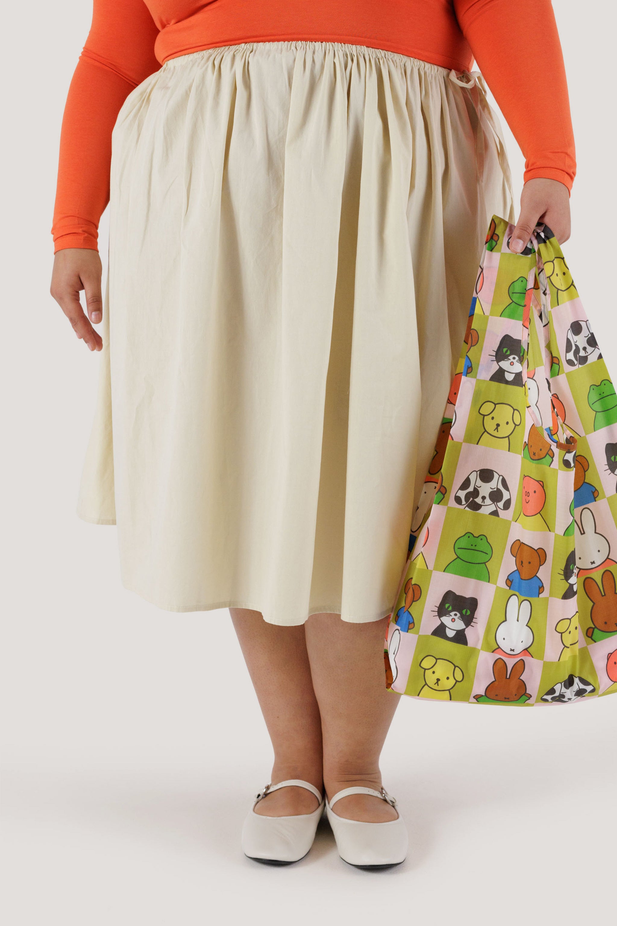 女人示範手提 Miffy 聯名環保時尚購物袋 - 經典,上有綠色米色格紋,印有 Miffy 和他的好朋友圖案。
Baggu - Baggu x Miffy - Standard Baggu · TINGKO SELECT